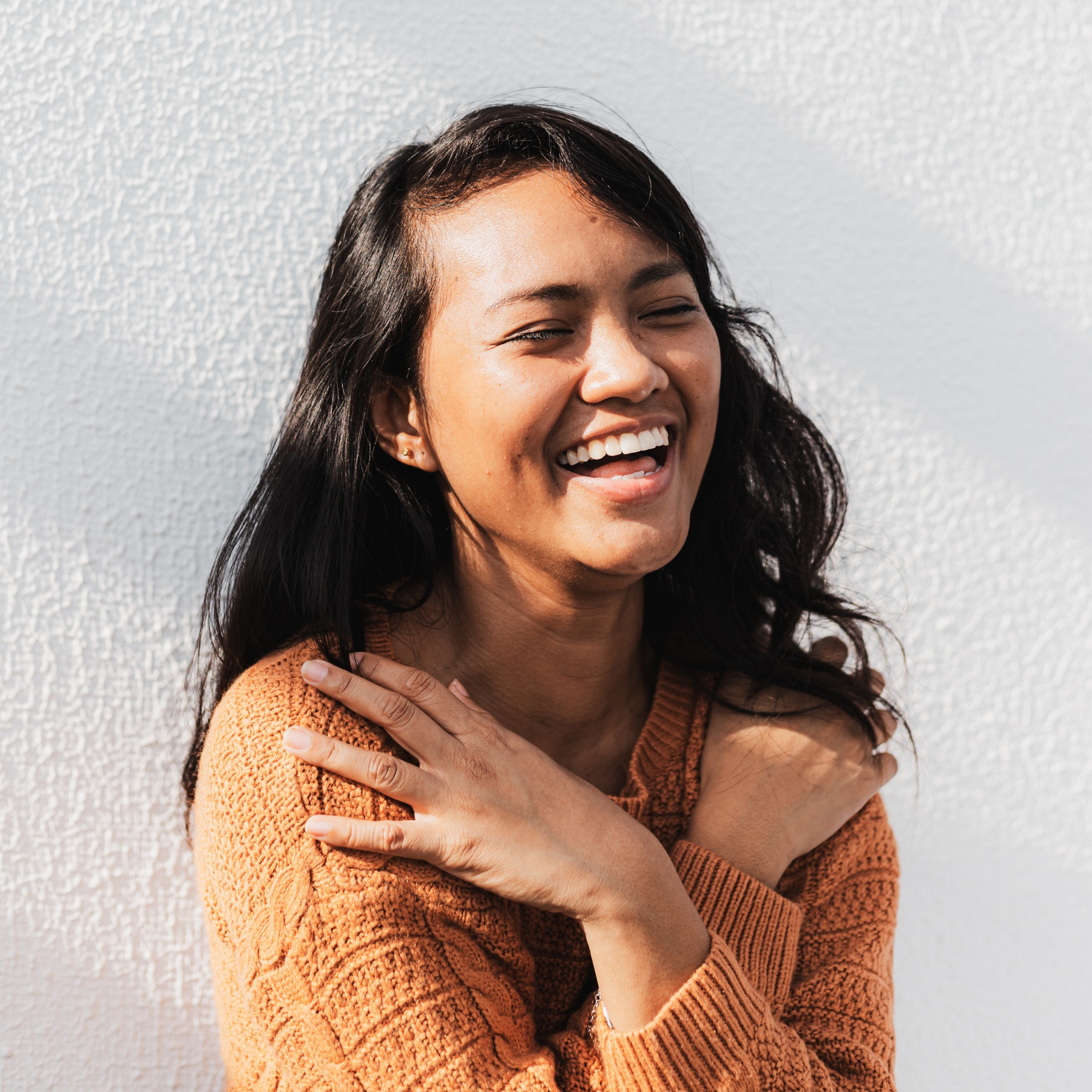Woman giving her self a supportive hug and smiling